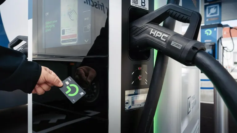 мъж на зарядна станция с OMV бизнес карта E-Mobility