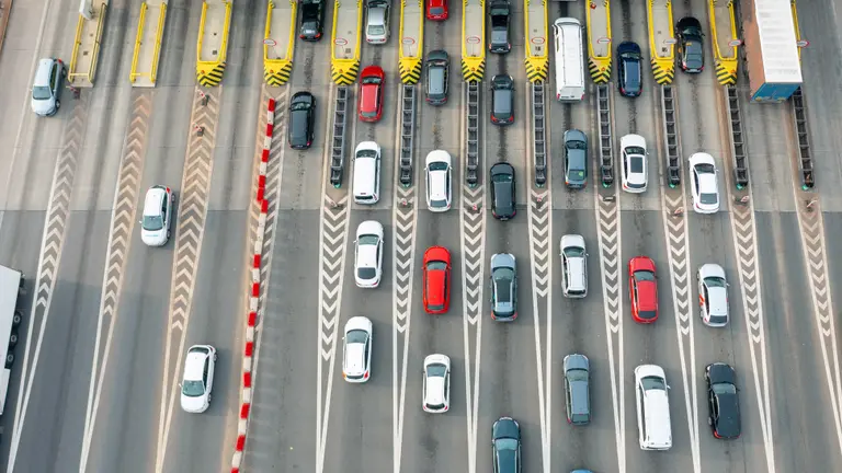 An aerial view of a busy toll road with many cars queuing.
